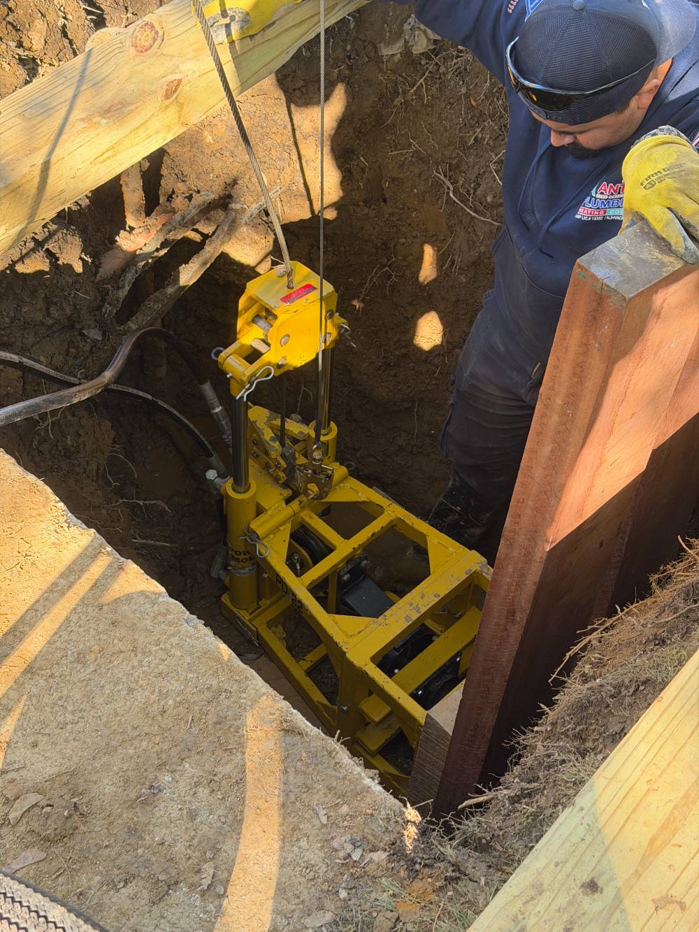 Technician working in a trench with hydraulic equipment