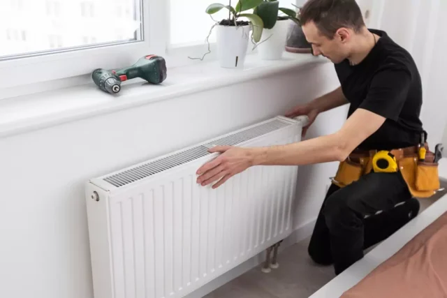 A worker installing a radiator.