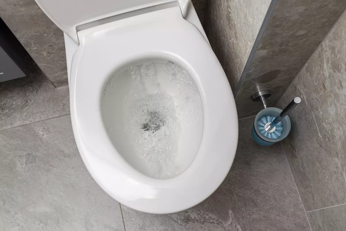 A view down into a running toilet.