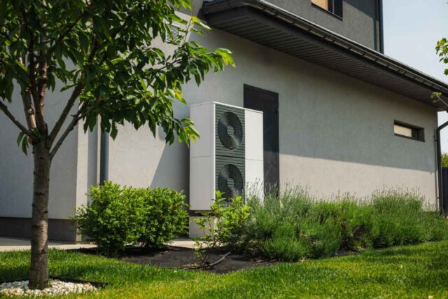 A heat pump on the side of the house.
